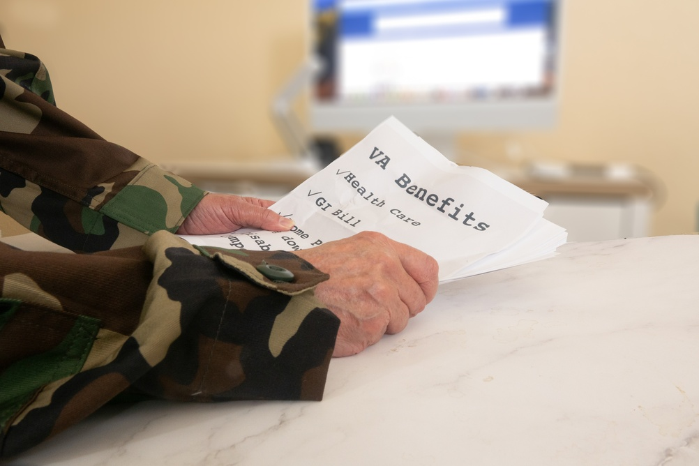person in a camouflage uniform holds papers