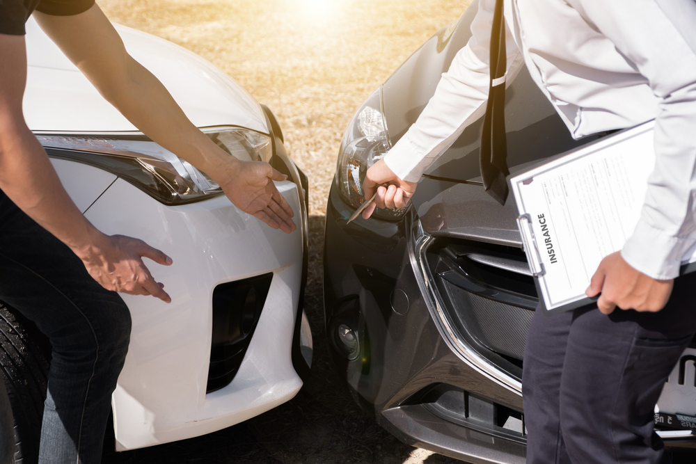 Rear-end car accident involving a blue and a black vehicle with two drivers.